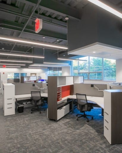 A man in a labcoat and other personal with protective equipment holds a long pipette in a lab at the Bioscience and Technology Business Incubator in Lawrence, KS.